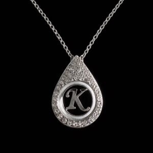 Ασημί κολιέ με μονογράμμα “Χ” μέσα σε δάκρυ διακοσμημένο με λαμπερές πέτρες. Κομψό και προσωποποιημένο κόσμημα με διακριτή λάμψη.