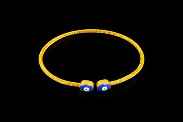 Χρυσή βέργα χειρός με σχέδιο μάτι σε μπλε χρώμα στα άκρα. Μοντέρνα και διακριτική, προσφέρει προστασία και στυλ.