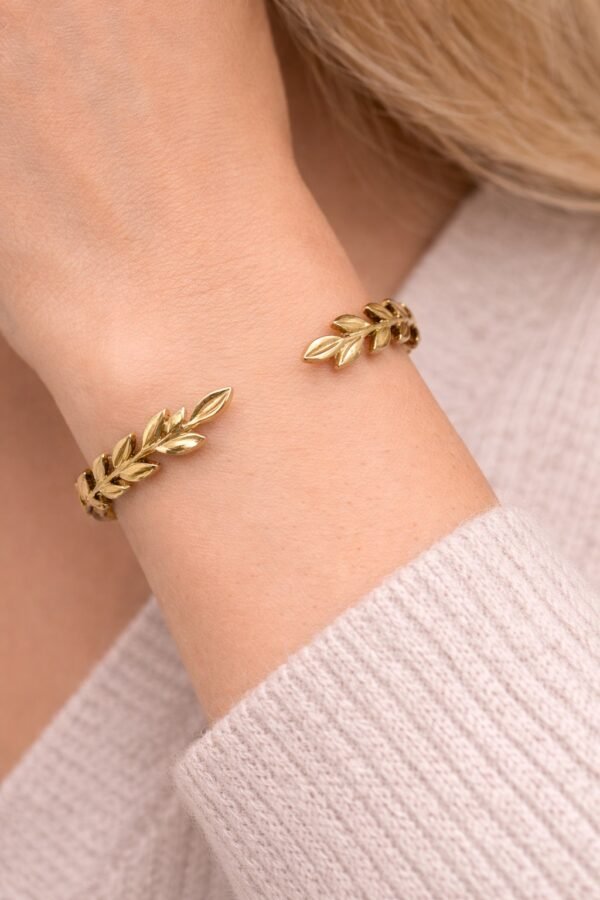 Βραχιόλι σε χρυσό τόνο, με ανάγλυφο σχέδιο φύλλων δάφνης.