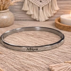 0-02-05-6fdfc11fcffa02c65729a484e3ffacf98cf70ab6b0e208e9b22dace652a51533_46cd2c560d767de8 Ατσάλινη χειροπέδα σε ασημι απόχρωση, χαραγμένη με το όνομα ΑΘΗΝΑ.