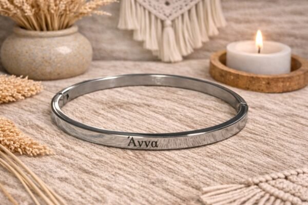 0-02-05-7c23a31915ac00b1725b21fee7c918ed71ad63d12c1afec1b2aaf39920321165_dc3ff2721d314636 Ατσάλινη χειροπέδα σε ασημί απόχρωση με χαραγμένο το όνομα Άννα.