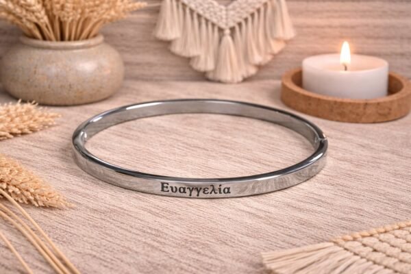 Ατσάλινη χειροπέδα σε ασημί απόχρωση, με χαραγμένο το όνομα ΕΥΑΓΓΕΛΙΑ.