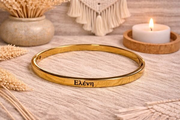 Ατσάλινη χειροπέδα σε κομψή χρυσή απόχρωση με χαραγμένο το όνομα ΕΛΕΝΗ.