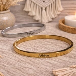 0-02-05-bd07d098fa01219494a1041b1c4a4273a1c103e96376ee0553b0f4dbf98010bc_3114e6c58bb707eb Ατσάλινη χειροπέδα σε χρυσή απόχρωση, χαραγμένη με το όνομα ΑΘΗΝΑ.