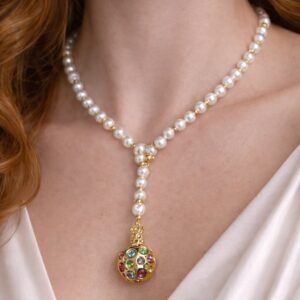 Κολιέ από πέρλες με ιδιαίτερο κεντρικό στοιχείο σε χρυσό τόνο.